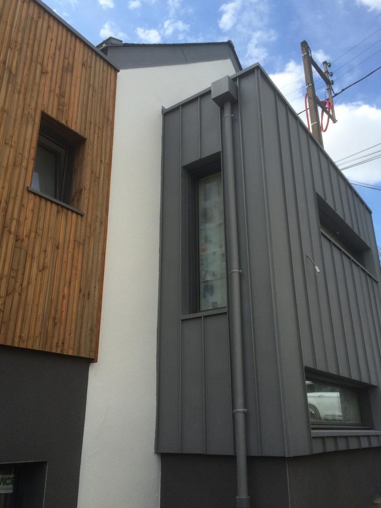 Façade tri-matériaux construction contemporaine Nantes — bardage bois, bac acier, enduit blanc — Art'Home Travaux
